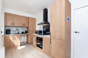 a kitchen with wooden cabinets and a stove at 2 Bedroom House-Free Parking in Methil