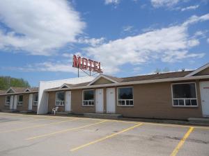 an empty parking lot in front of a motel at Motel Le Rond Point in Metabetchouan