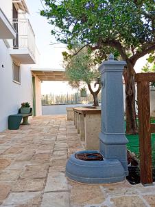 a stone patio with a fountain in front of a building at La Fontana in Montalbano +4 photos