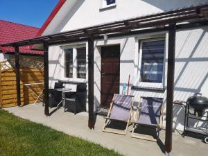a screened in patio with chairs and a grill at Domki letniskowe Reda in Rusinowo +60 photos