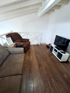 a living room with a couch and a flat screen tv at Flat na Praia de Maresias - 100 metros da praia in São Sebastião