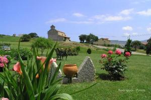 um jardim com flores e um edifício ao fundo em Costa Trasmiera em Langre