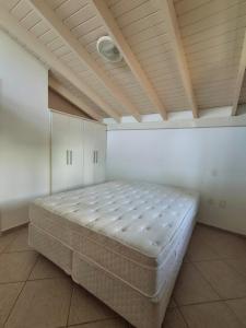 a bed in a room with a ceiling at Flat na Praia de Maresias - 100 metros da praia in São Sebastião +23 photos