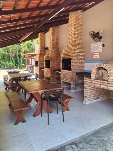 an outdoor patio with tables and a brick oven at Flat na Praia de Maresias - 100 metros da praia in São Sebastião