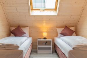 two beds in a room with a window at Domki Sarbinowo Elizjum in Sarbinowo +33 photos