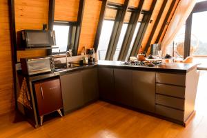 a kitchen with a counter with a sink and a tv at Cabana Silfra in Gonçalves