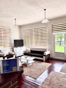 a living room with a couch and a table at La Bocca Apartment - Airport, Parking, AC, Bidet, Coffee Machine, PS3 in Sarajevo