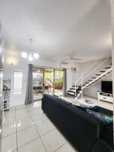 Una sala de estar con un sofá y una escalera. en Bakers Sea Breeze Escape, en North Ward 25 fotos más