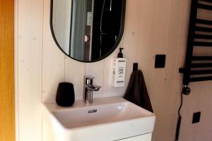 a bathroom with a sink and a mirror at Mirage - Dreamy Seaside Design Cabin in Engure +30 photos