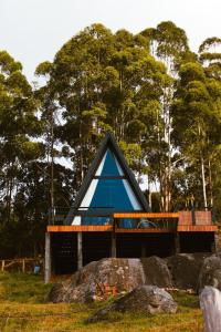 a blue house in a field with trees in the background at Cabana Silfra in Gonçalves