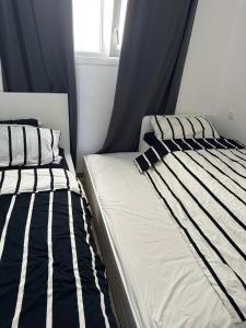 a bedroom with two beds with black and white pillows at Appartement Bella Vesta JUSQU A 6 PERSONNES in Cabo Negro