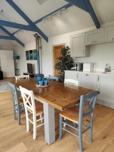 a kitchen with a wooden table and chairs at Ocean Heart Studio- Luxury, Rural Retreat in Wendron +16 photos
