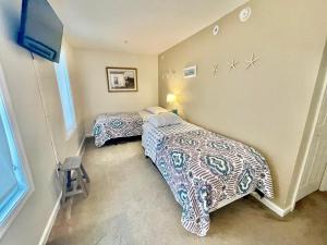 ein Schlafzimmer mit zwei Betten und einem Fernseher in der Unterkunft Delano 3i in Rehoboth Beach