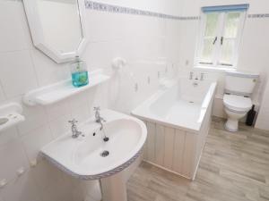 a white bathroom with a sink and a toilet at Sunnyvale Cottage in Penzance