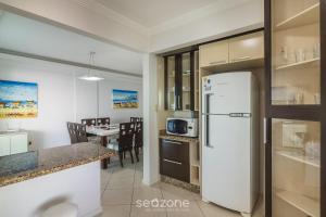 a kitchen and dining room with a white refrigerator at Apto 3Qtos Vista Mar a 130m da Praia RDK0801 in Perequê