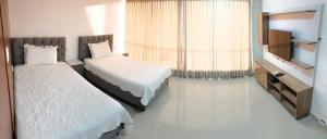 a hotel room with two beds and a window at Lofts Mediterraneo in Barranquilla +21 photos