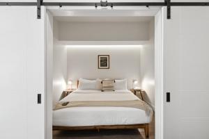 - une chambre avec des murs blancs et un lit avec des draps blancs dans l'établissement Urban Elegance | Espadin LoHi, à Denver