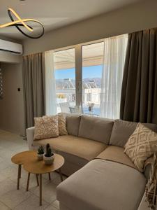 a living room with a couch and a table at DIVINUS Luxury Stay in Markopoulo