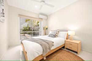 UranganBeachfront Luxury with Ocean Views and Alfresco Dining的一间带床和窗户的白色卧室