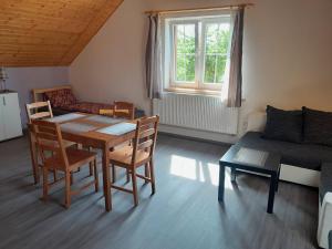 a living room with a table and chairs and a couch at Apartmány Dunice 2 - celý dům in Dunice