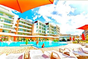 a resort with a swimming pool with chairs and umbrellas at GRAND KAMELIA Apartments Sunny Beach in Sunny Beach