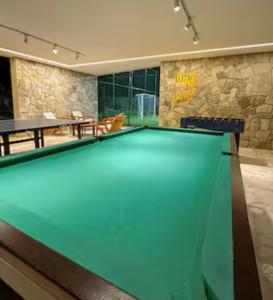 a pool table in a living room with a table at Muro Alto Comfort - Family Flat - 2 quartos in Ipojuca