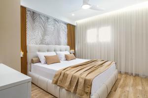 a white bedroom with a large white bed with pillows at Azure Bliss in Nikiti