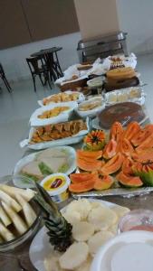 einen Tisch mit vielen verschiedenen Lebensmitteln in der Unterkunft Hotel Vento Sul in Teixeira de Freitas