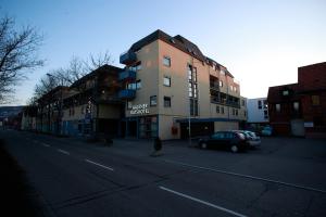 a building with a car parked on the side of a street at Ratshotel - City Aparthotel Aalen in Aalen