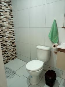 a white bathroom with a toilet and a shower at Aconchego da Kika in Caruaru