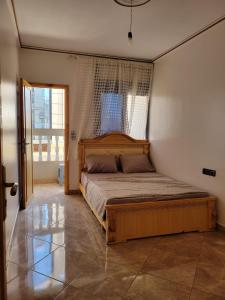 a bedroom with a large wooden bed with a window at Superbe Appartement bouki in Al Hoceïma
