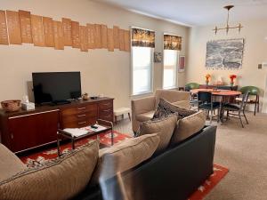 a living room with a couch and a tv and a table at Falls Retreat - Walk to the Falls, the Casino and all Downtown Restaurants - Across from the Aquarium in Niagara Falls