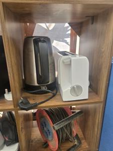 a tv and a toaster and a printer on a shelf at Sunshineglamping2024 in Alcantarilha