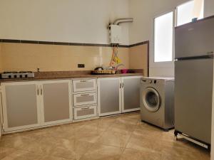 a kitchen with a refrigerator and a washing machine at Superbe Appartement bouki in Al Hoceïma