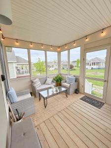 a screened in porch with couches and a coffee table at Magnolia Moon Cottage at East Lake Shores in Cherry Valley