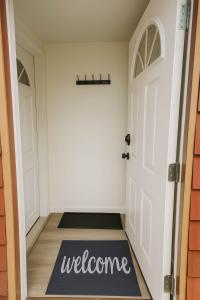 a hallway with a welcome mat in front of a door at Quaint Attic Suite with Heated Pool Year-Round in Victoria +24 photos