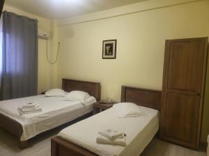 a room with two beds and a shower at Hotel Acropole in Bucharest