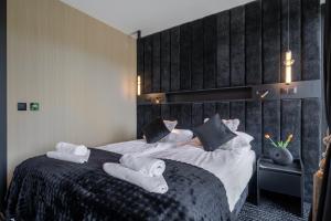 a hotel room with two beds with towels on them at TATRAHOLIDAY - Apartament Mountain Pool & Spa in Białka Tatrzanska +51 photos
