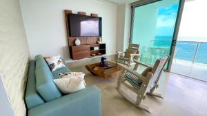 a living room with a blue couch and a tv at Magico Apartamento Frente al Mar 3 Habitaciones TR52 in Coveñitas