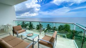 a balcony with chairs and a view of the ocean at Magico Apartamento Frente al Mar 3 Habitaciones TR52 in Coveñitas