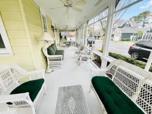 リホボスビーチにあるVirginia avenue 18の白籐椅子と緑のクッションが備わるポーチ