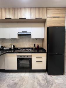 a kitchen with a stove and a black refrigerator at Luxury Appartement fes city fleur in Fez