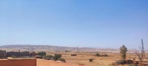 a view of a desert with mountains in the background at DAIFLAH Guesthouse & Hostel in Oulad Rguia +21 photos
