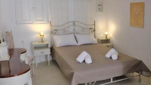 a bedroom with a bed with two white pillows on it at Anetta's House in Agia Marina