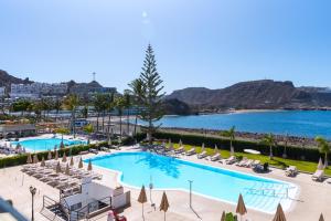 a view of a pool with chairs and a beach at Paradise Playa del Cura in Las Palmas de Gran Canaria