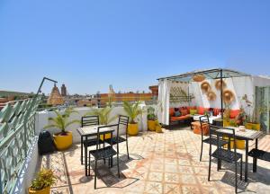 a patio with tables and chairs on a roof at Riad N57 in Marrakech