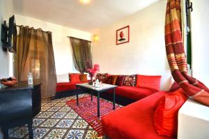 a living room with red couches and a table at Riad N57 in Marrakech