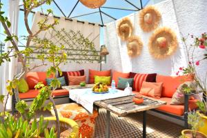 a patio with an orange couch and a table at Beldi House in Marrakesh