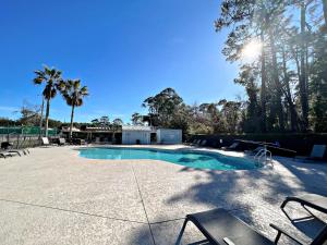 ein Schwimmbecken mit Stühlen und Palmen in der Unterkunft Bayview in Orange Beach