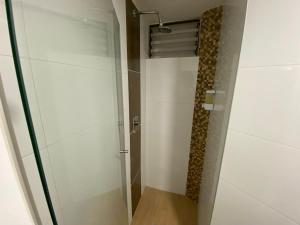 een douche met een glazen deur in een badkamer bij comodidades en el centro de la ciudad in Manizales +1 foto